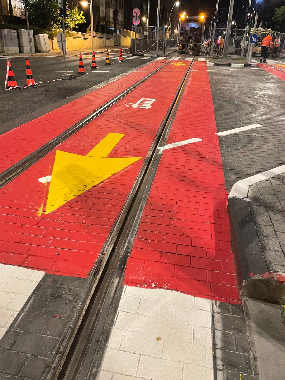 הגוונה אדומה דו־רכיבית במפגש רכבת קלה וכביש